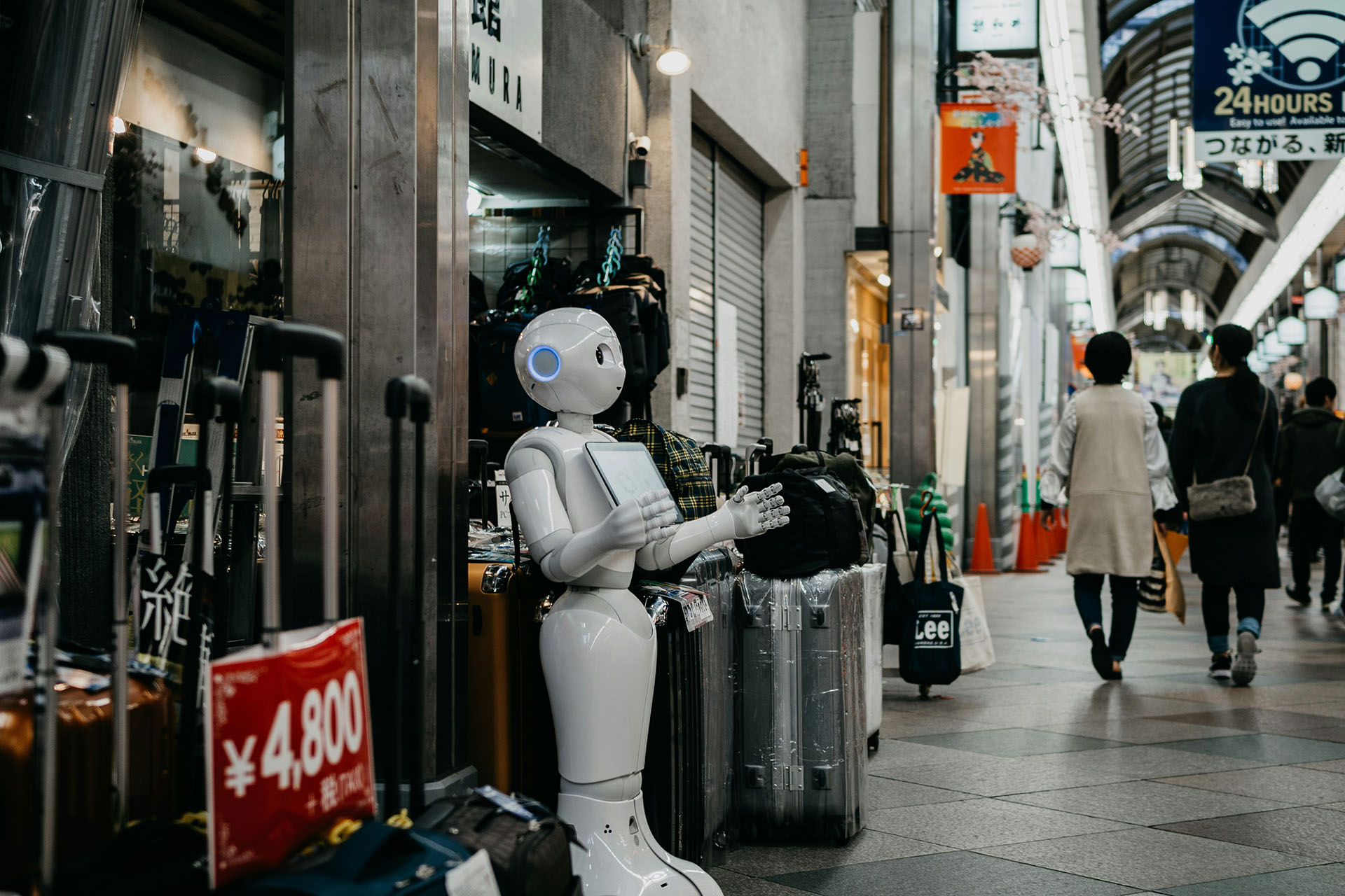 A large robot outside a shop on a busy highstreet.