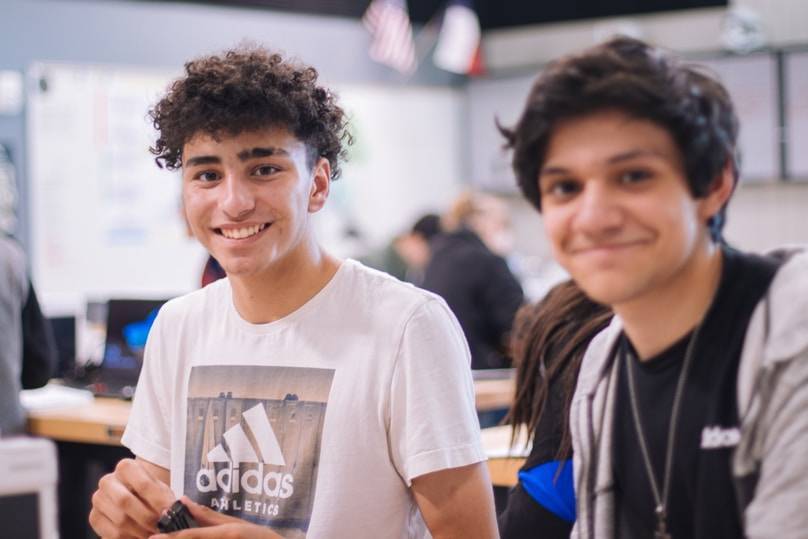 Two smiling students in a workshop.