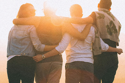 A group of friends look out over a sunlit vista.