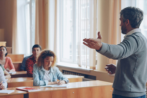 A lecturer giving a talk to a small group of students.